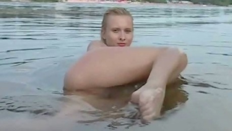 Slender blonde teen demonstrates her nude body outdoors